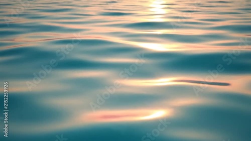 Gentle ripples on the surface of calm blue water at sunset