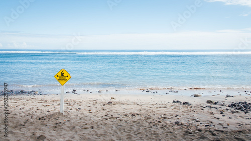 Paysage d'une plage à La Réunion avec un panneau jaune d'avertissement des risques de noyade. Attention aux courants dangereux dans la mer. Dangers de la mer.