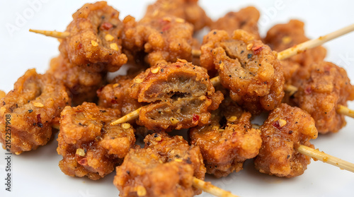Heap of spicy Filipino proven snacks, cornstarch flour deep fried chicken offals (gizzards) on white background. Asian street foods, fast food and menu ideas