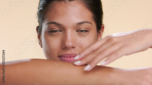 Detailed view of cosmetic model touching her forearm over beige bg | Beauty video revealing unwanted hair removal concept