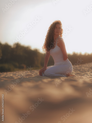 Bottom view of Amputee Woman Kneeling on Sand in Sunset