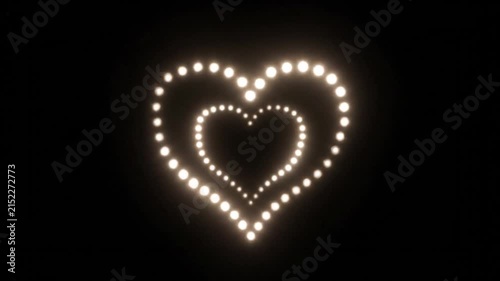 Glowing heart shape formed by bright lights on black background