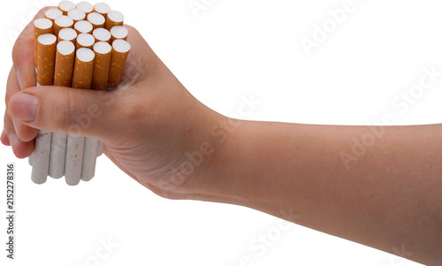 A hand is tightly gripping a handful of cigarettes with white filters and orange-yellow bodies, set against a transparent background.