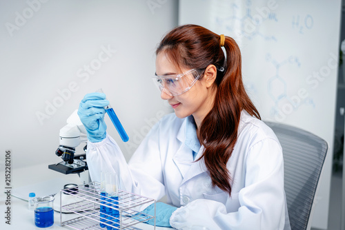 Science professional researches chemicals laboratory examining blue liquid test tube experiment medical healthcare discovery innovation