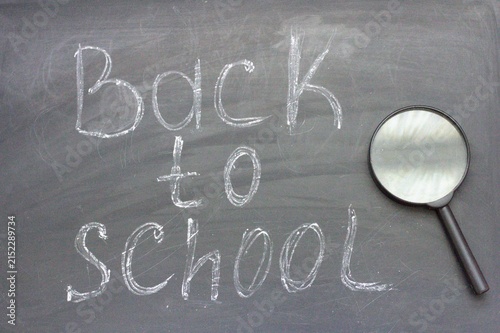 Back to school with magnifying glass on blackboard