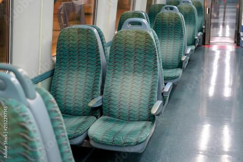 Konstfotografi Row of upholstered seats inside a passenger train cabin on a bright day with emp
