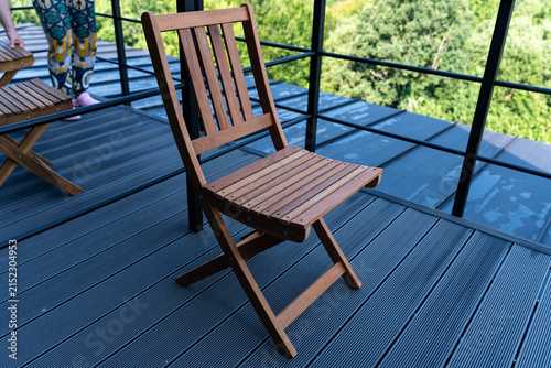 Small foldable deck chair on wpc patio floor close up shot at a mountain weekend home at summertime.