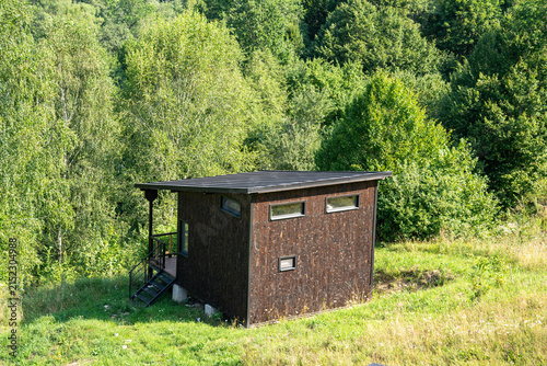 Small hut, weekend, vacation house in green forest at summertime.