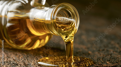 An illustration of olive oil, with olive oil pouring from a glass bottle. Rustic-style presentation.