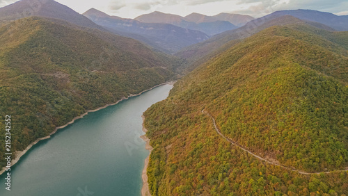 Фотография Aerial view of turquoise Zhinvali reservoir surrounded by green forested Caucasu
