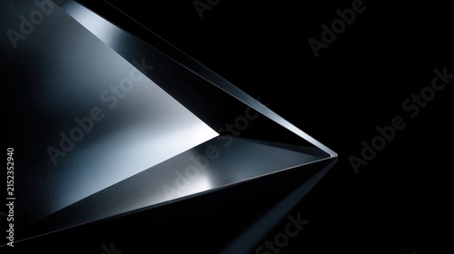 Abstract dark glass geometric shapes with highly polished surfaces and sharp edges.