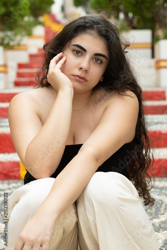Young woman sitting on colorful stairs in calpe