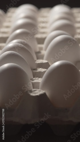 man's hands taking fresh white chicken eggs out of cardboard box