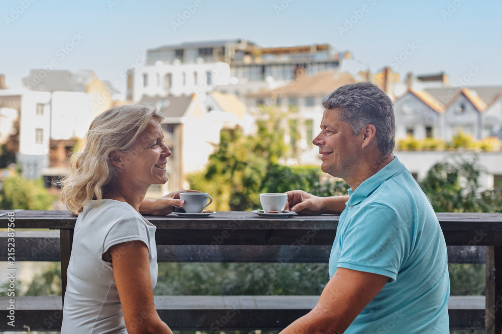 Fototapeta premium Smiling mature couple enjoying coffee on a terrace