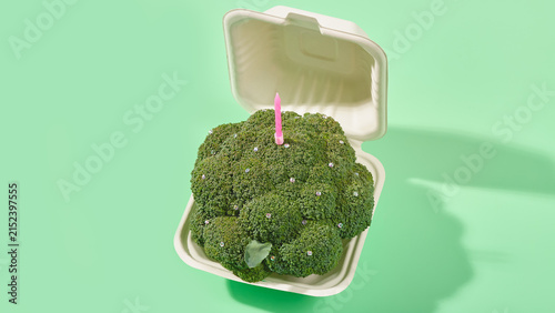 Broccoli with birthday candle in biodegradable container