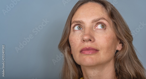 Authentic portrait of mature woman with natural realistic skin texture and genuine thoughtful expression