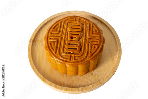 Fotografía A mooncake on bamboo plate isolated on white background, tradition Chinese moon cake, sweet dessert for mid autumn celebration