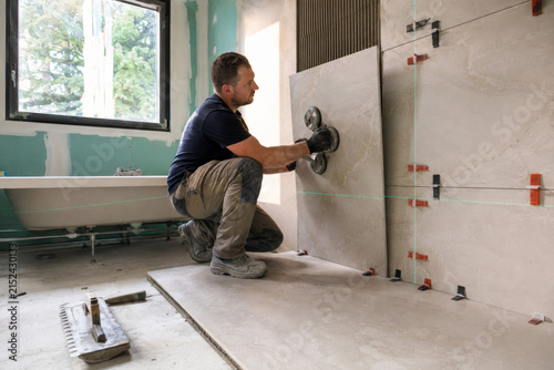 Trabajo de instalación de baldosas en un baño en remodelación