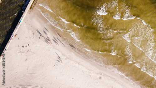 Photography Drone shot of seashore coastline with breakwater pier and sea waves during sunse