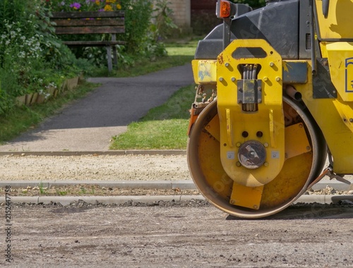 Fotografía Close-Up of a Yellow Road Roller Steel Drum at a Residential Sidewalk and Park C