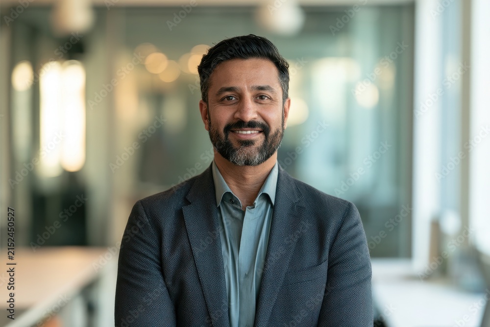 Fototapeta premium Professional executive portrait of a smiling leader in a contemporary workplace