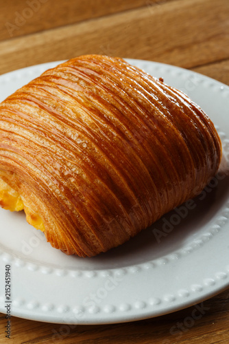 Obraz na płótnie Close-up of glossy golden laminated pastry with creamy filling and precisely def