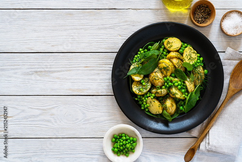 Healthy new potato salad with fresh peas, baby spinach, herbs, and mustard dressing