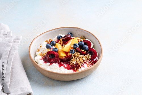 Healthy summer breakfast with cottage cheese, granola and fresh berries and homemade berry jam