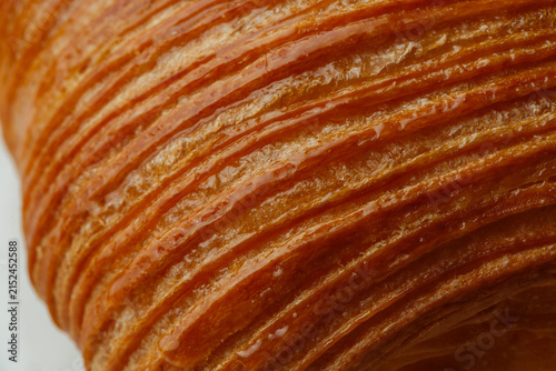 фотографія Extreme close-up of golden flaky pastry layers creating a rich laminated dough t