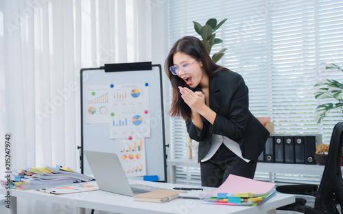 Canvastavla Surprise Success: A young businesswoman expresses astonishment and excitement while looking at her laptop in a modern office setting