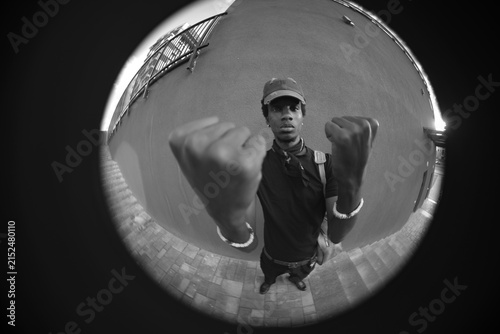 Cuadro en lienzo Circular fisheye black and white portrait of man showing fists with copy space