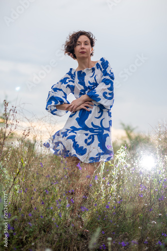 Woman in Blue Patterned Dress Standing in Wildflower Field
