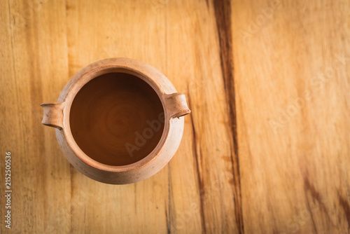 Close-up of an Andean ceramic with a clay pot and plates on a rustic wooden table