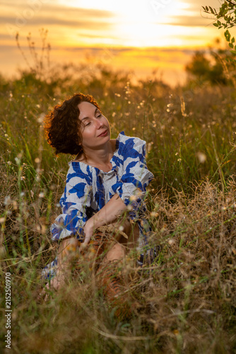 Woman Relaxing in Meadow at Sunset