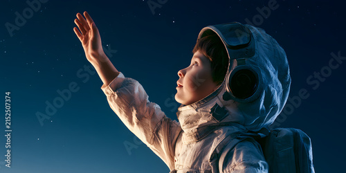 A young boy in a spaceman costume gazes at the night sky, filled with dreams of space exploration. A joyful child imagines a bright and promising future