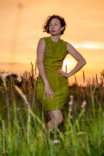 Woman in Green Dress at Sunset in Tall Grass
