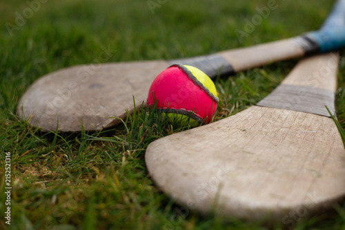Obraz na plátne Wooden hurley sticks resting on grass beside brightly colored training ball slio