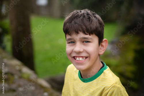 Принти на полотні A cheerful young boy smiles broadly in close-up outdoor portrait, conveying joy, innocence and youthful energy