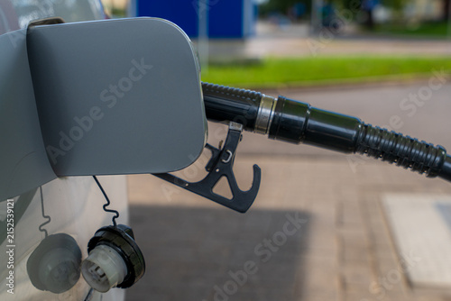 Obraz na plátne Close-Up of a Fuel Pump Nozzle Inserted into a Vehicle Fuel Tank During Refuelin