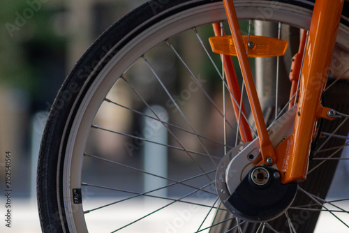 Canvas Print A close up of a bicycle wheel with orange spokes