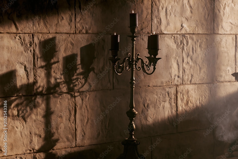Obraz premium Antique candelabra with lit black candles casting shadows on a stone wall