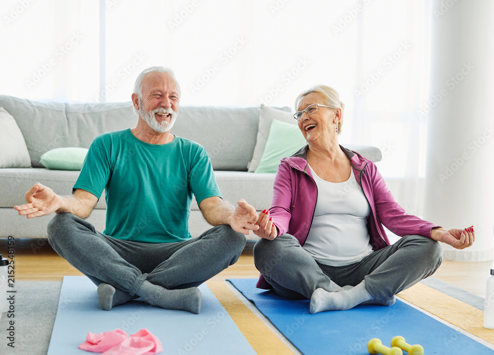 Fototapeta premium Senior couple exercise stretching or doing yoga at home, health care and active seniors concept