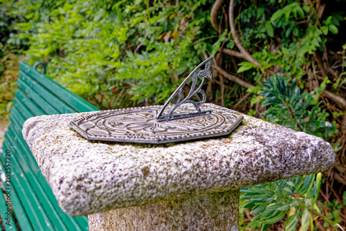 Antique Brass Sundial on Weathered Stone Pedestal in Estate Garden