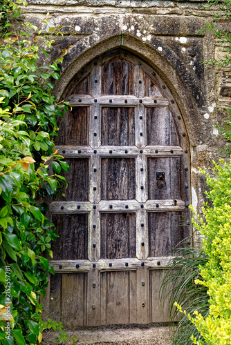 Antique Gothic Arched Wooden Door and Garden Hedges