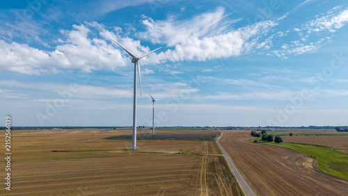 Aerial drone view of wind turbine and solar panel farm surrounded by agricultural fields – renewable energy landscape photo