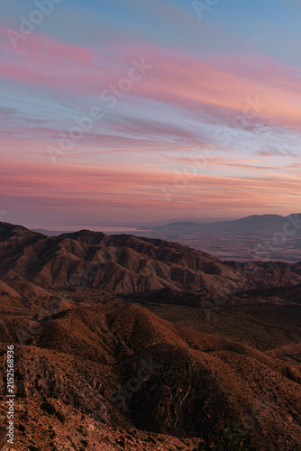 Layered desert mountains under sweeping pink clouds at sunset in Joshua Tree National Park, California