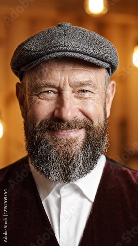 Smiling senior man in a flat cap looking at camera portrait