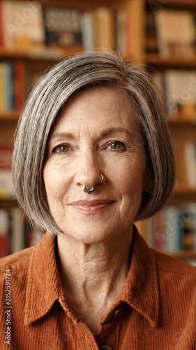 Smiling senior woman with septum ring looks at camera
