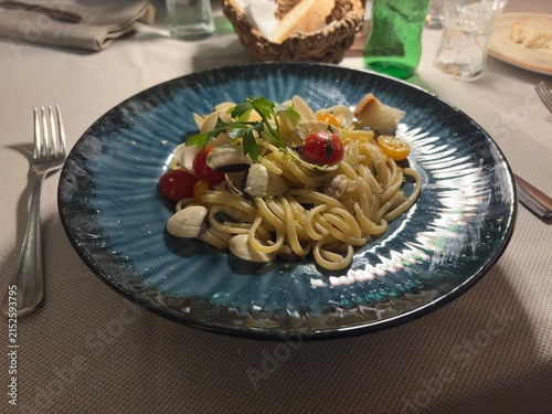 Fotografie Gourmet Seafood Pasta: Spaghetti alle Vongole with Cherry Tomatoes on a Blue Cer