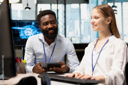 Photography Cheerful senior programmer teaches an intern to train deep learning models for anomaly detection, combining workplace mentoring with practical artificial intelligence development in a modern office